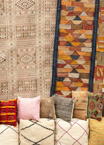 pexels-photo-11537258-11537258 Vibrant Moroccan textiles and traditional patterns featuring colorful rugs and pillows on display.